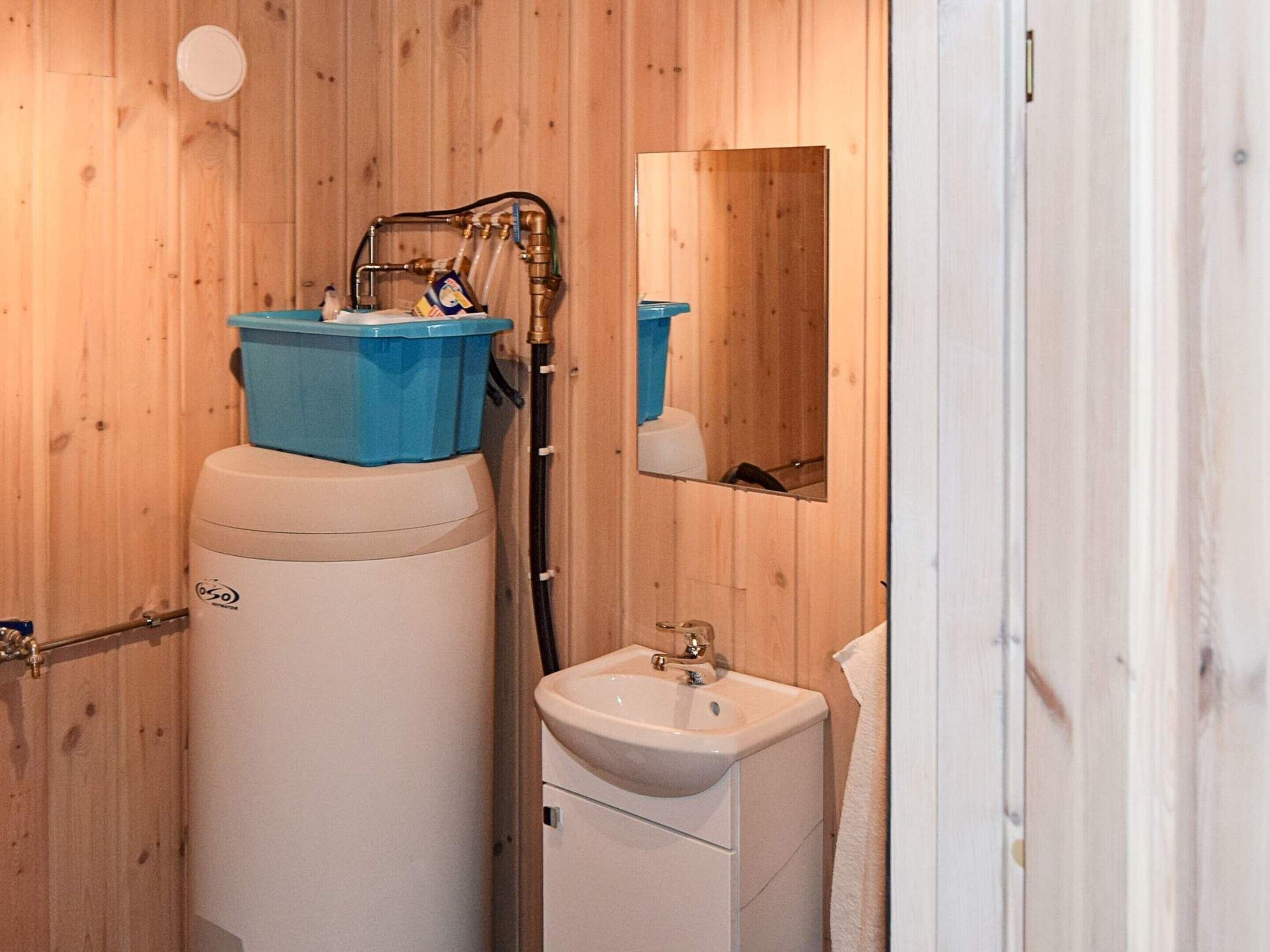 A compact bathroom with a toilet, sink, and a water heater.