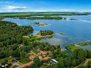 Vista aérea de una comunidad junto al lago con casas, barcos y un área boscosa.