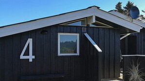A wooden building with a number '4' sign, a bench, and a satellite dish.