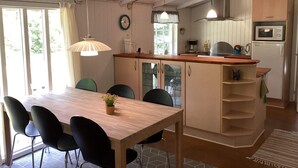 Une cuisine compacte avec une table et des chaises en bois, un four encastré et un four à micro-ondes.