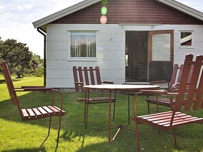 Une maison dotée d’un patio comprenant une table et quatre chaises.