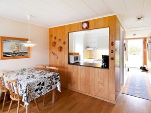 Un comedor con una mesa de madera, sillas y un cuadro en la pared.