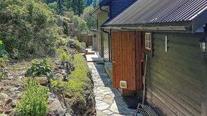 Un chalet rustique avec un sentier de pierres menant à l’entrée.