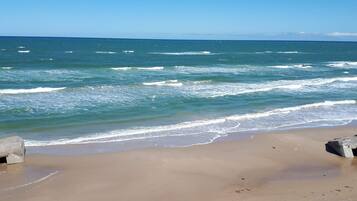 A beach with waves and a clear sky.