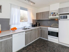A modern kitchen with a built-in oven, microwave, and coffee maker. - 8 Person Holiday Home in Bindslev-by Traum (Bindslev)