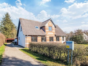 A two-story house with a sloped roof, a small window, and a visible garage. - 8 Person Holiday Home in Bindslev-by Traum (Bindslev)