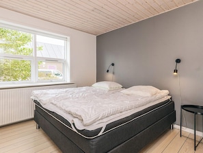 A bedroom with a bed, a window, and two wall-mounted lamps. - Peaceful Holiday Home in Skagen Located near Village Center (Skagen)