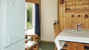 A room with a dining table, chairs, a refrigerator, and a window with curtains. - 3 Person Holiday Home in Frei (Kristiansund)