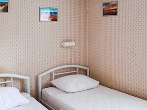 A small, single-bed room with floral wallpaper, a white headboard, and two framed pictures on the wall. - 5 Person Holiday Home in Mellbystrand (Mellbystrand)