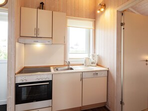 A compact kitchen with a Siemens oven, a coffee maker, and a sink. - Holiday Home in GrÃ¶mmitz (Groemitz)