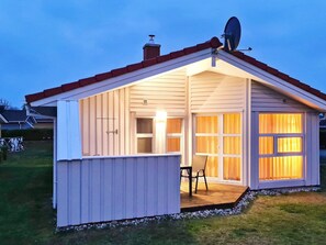 A small, single-story shed with a sloped roof, a satellite dish, and a sliding glass door. - Holiday Home in GrÃ¶mmitz (Groemitz)
