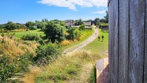 A rural landscape with a dirt path leading to a cluster of buildings. - 3 Person Holiday Home in Hollviken-by Traum (Hollviken)