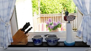 A kitchen window with a view of a wooden fence and greenery. - 3 Person Holiday Home in Hollviken-by Traum (Hollviken)