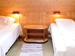 A room with two beds, a small wooden table, and two wall-mounted lamps. - 4 Star Holiday Home in Sorbovag (Hyllestad)