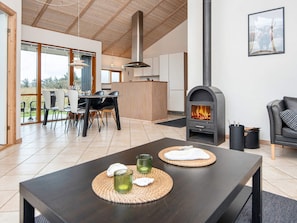 Una sala moderna con chimenea, comedor y cocina.