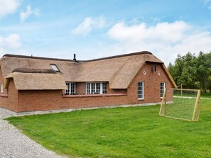 A large brick building with a thatched roof, a visible chimney, and a small window. - Tranquil Holiday Home in Ulfborg With Sauna (Ulfborg)