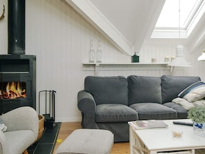 A cozy living room with a fireplace, grey sofa, and a white table with a lamp. - 5 Person Holiday Home in Asnaes-by Traum (Asnaes)