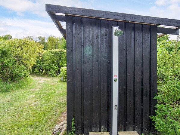 A wooden structure with a vertical pole, a door, and a small sign.