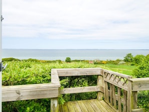 A wooden deck with a view of the sea and greenery. - 5 Person Holiday Home in Asnaes-by Traum (Asnaes)