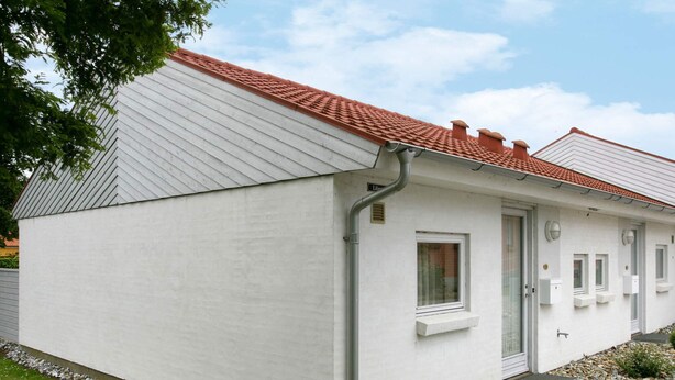 A single-story building with a sloped roof, a door, and a window.