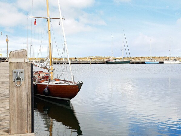 A wooden dock with a boat moored at the pier. - Cozy Holiday Home in Ã†rÃ¸skÃ¸bing near Harbour (Aeroskobing)