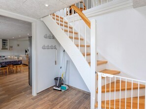 A staircase with wooden steps and white railings, leading to an upper floor.