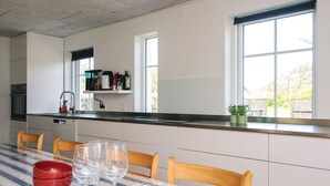 A modern kitchen with a dining area. - 4 Star Holiday Home in Lokken (Lokken)