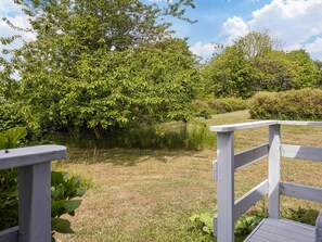 A wooden deck with a view of a grassy area and trees. - 6 Person Holiday Home in Hasle (Hasle)