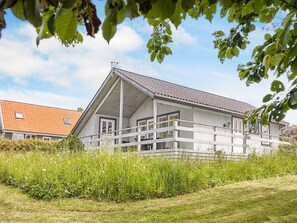 A two-story house with a balcony, surrounded by greenery. - 6 Person Holiday Home in Hasle (Hasle)