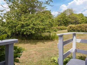 A wooden deck with a view of a grassy area and trees. - 6 Person Holiday Home in Hasle (Hasle)