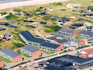 Ett flygbildsbild av ett kustområde med bostadshus och en stor kommersiell byggnad som är märkt med texten ”Danland”.