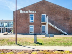 Un edificio de ladrillo con una escalera y un pequeño balcón, identificado con la leyenda 'Ocean House'.