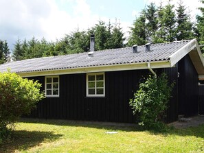 A black wooden house with a sloped roof and two windows. - 4 Star Holiday Home in Blokhus (Blokhus)