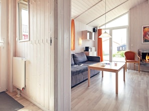 A modern living room with a sofa, a table, and a fireplace. - Holiday Home in GrÃ¶mmitz (Groemitz)