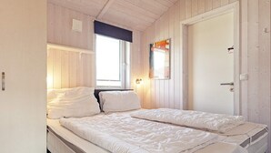 A room with two beds, a window, and a door. - Holiday Home in GrÃ¶mmitz (Groemitz)