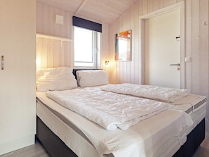A room with two beds, a window, and a door. - Holiday Home in GrÃ¶mmitz (Groemitz)