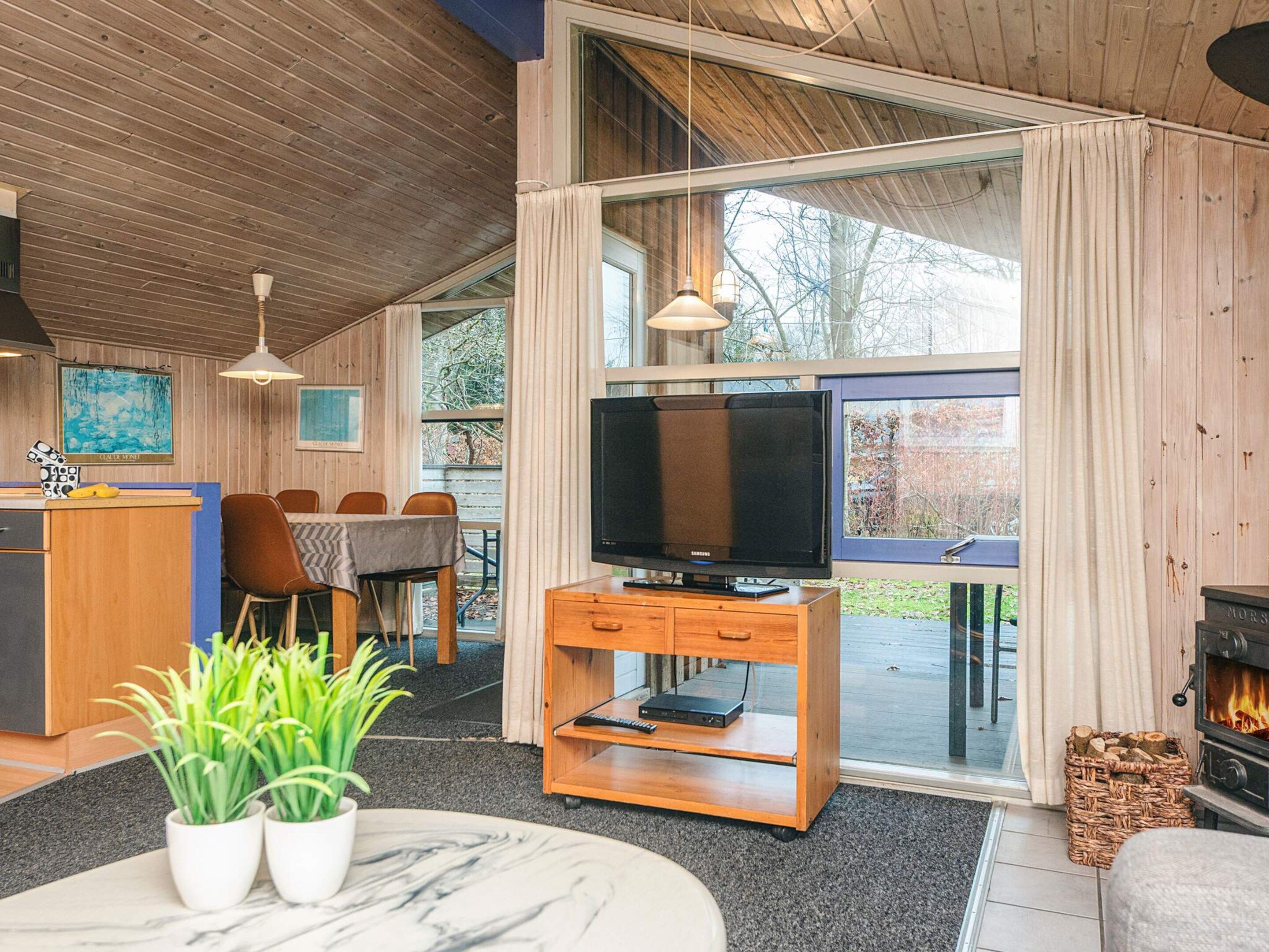 A modern living room with a television, wooden furniture, and a fireplace.