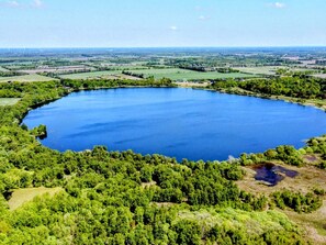 Un grand lac circulaire, entouré d’une forêt dense et verdoyante.
