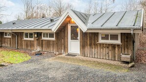 A wooden cabin with a metal roof, a front door, and windows. - 6 Person Holiday Home in Ansager (Ansager)