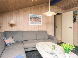 A room with a grey sofa, a marble coffee table, a green plant, a wall-mounted lamp, and a framed picture. - 6 Person Holiday Home in Ansager (Ansager)