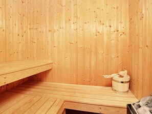 A wooden sauna with benches and a bucket for water. - Holiday Home in Gelting (Gelting)