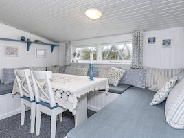 Una habitación acogedora con una mesa de comedor, sillas y un banco con cojines.