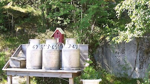 A wooden table with four large containers and a white urn. - 5 Person Holiday Home in Kungshamn (Kungshamn)