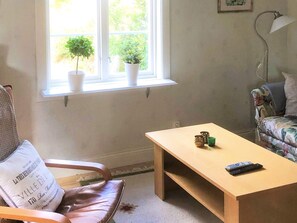 A room with a window, a chair, a table, a lamp, and a couch. - 5 Person Holiday Home in Kungshamn (Kungshamn)