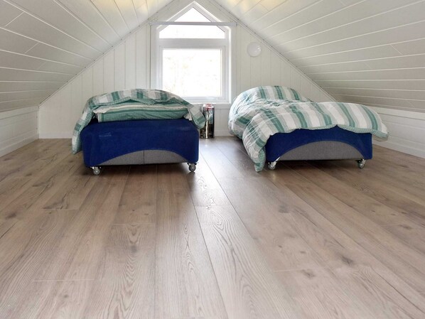 A small attic bedroom with two single beds, wooden flooring, and a skylight. - 5 Star Holiday Home in Brattvag (Ålesund)