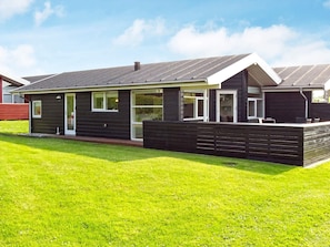A modern house with a flat roof, large windows, and a well-maintained lawn. - 6 Person Holiday Home in Tranekaer (Tranekaer)