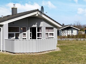 A two-story house with a covered porch, a chimney, and a satellite dish.