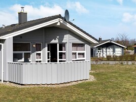 A two-story house with a covered porch and a chimney.
