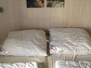 A double bed with white bedding and a small bedside table. - Holiday Home in GrÃ¶mmitz (Groemitz)