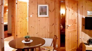 Un intérieur en bois comprenant une table à manger, des chaises et un téléviseur.